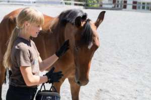 fille blonde tenant un cheval